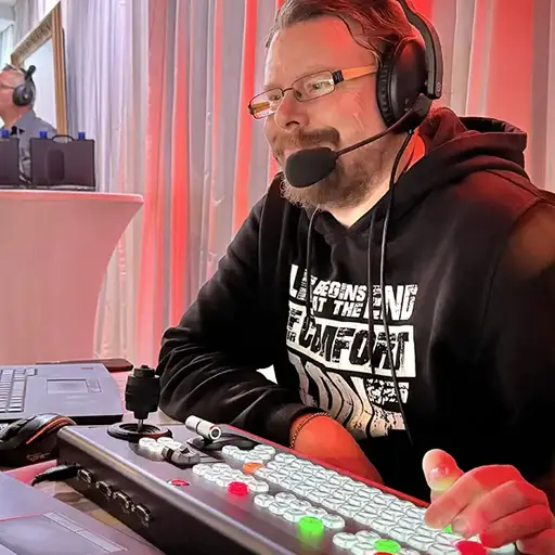 Bildregisseur während einer Live-Produktion für eine Vortragsveranstaltung mit Hybrid- und Livestream-Setup.